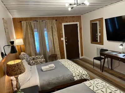 a bedroom with a bed and a desk and a television at High Point Mountain Motel in Wantage