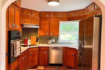 a kitchen with wooden cabinets and stainless steel appliances at The Mod Cabin in Bearsville
