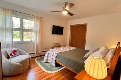 a bedroom with a bed and a couch and a window at The Mod Cabin in Bearsville