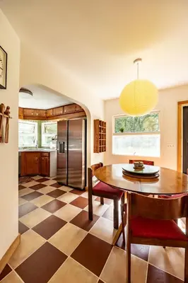a kitchen and dining room with a table and a checkered floor at The Mod Cabin in Bearsville