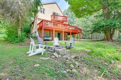 a house with chairs and a table in the yard at Pet-Friendly Home with Beach in Northville! in Northville