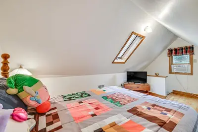 a bedroom with a bed with a quilt on it at Pet-Friendly Home with Beach in Northville! in Northville