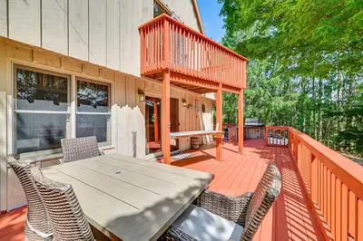 a deck with a table and chairs on a house at Pet-Friendly Home with Beach in Northville! in Northville