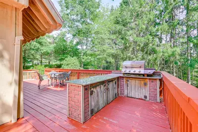 a patio with a grill on a wooden deck at Pet-Friendly Home with Beach in Northville! in Northville