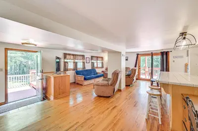 a kitchen and living room with a blue couch at Pet-Friendly Home with Beach in Northville! in Northville