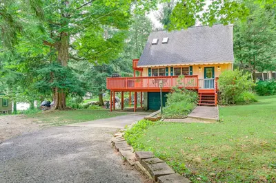 a small house with a red deck on a yard at Pet-Friendly Home with Beach in Northville! in Northville