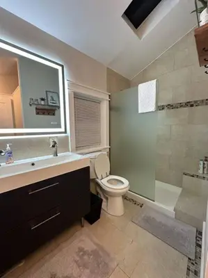 a bathroom with a sink and a toilet and a shower at Lovely private home in a serene neighborhood in Totowa