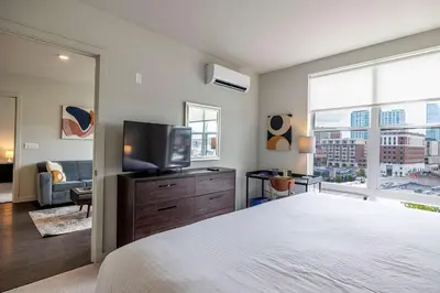 a bedroom with a bed and a flat screen tv at New Luxury Apt Downtown with Pool in Stamford