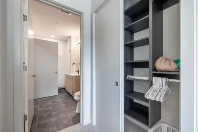 a bathroom with a toilet and a walk in closet at New Luxury Apt Downtown with Pool in Stamford