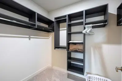 a walk in closet with black cabinets in a room at New Luxury Apt Downtown with Pool in Stamford