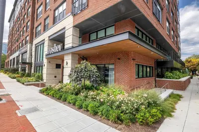 a large brick building with flowers in front of it at New Luxury Apt Downtown with Pool in Stamford