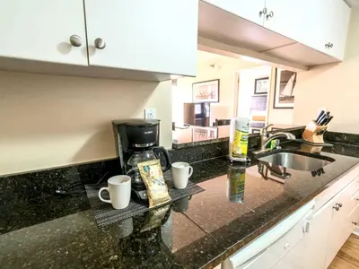 a kitchen counter with two coffee cups and a sink at Serene Apt Downtown in Stamford