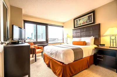 a hotel room with a bed and a flat screen tv at Serene Apt Downtown in Stamford
