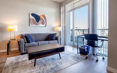 a living room with a couch and a table and a desk at Trendy Apt On Harbor with Gym in Stamford