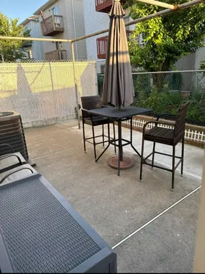 a table with chairs and an umbrella on a patio at Comfort Apartment Near Newark Airport in Newark