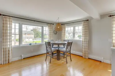 a dining room with a table and chairs and windows at Walk to Beaches Sunny East Haven Home with Grill in West Haven