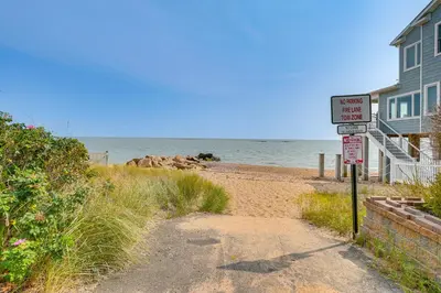 a sandy beach next to a house with a sign at Walk to Beaches Sunny East Haven Home with Grill in West Haven