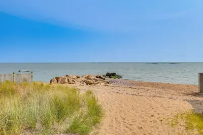 a sandy beach with rocks in the water at Walk to Beaches Sunny East Haven Home with Grill in West Haven