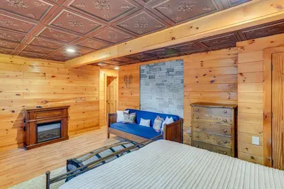 a bedroom with a blue bed and a fireplace at Spacious Wilmington Cabin Walk to Lake in Wilmington