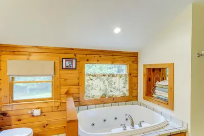 a bathroom with a tub and a window at Spacious Wilmington Cabin Walk to Lake in Wilmington