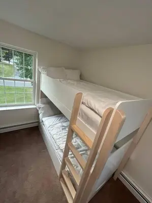 a bunk bed with a chair in a room with a window at Cozy Beautiful Pondside Luxurious Retreat in Monroe