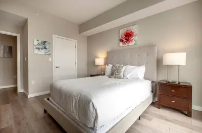 a bedroom with a large white bed and a nightstand at Luxury Apt On Harbor in Stamford
