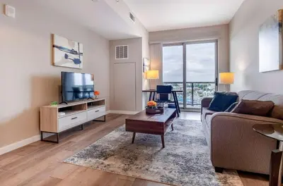 a living room with a couch and a tv at Luxury Apt On Harbor in Stamford