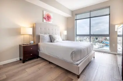 a bedroom with a large bed and a large window at Luxury Apt On Harbor in Stamford
