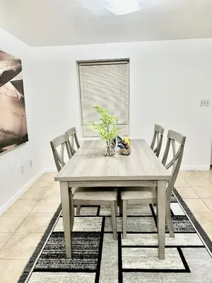 a dining room with a wooden table and chairs at Cozy Evergreen Apartment by Newark Airport in Newark