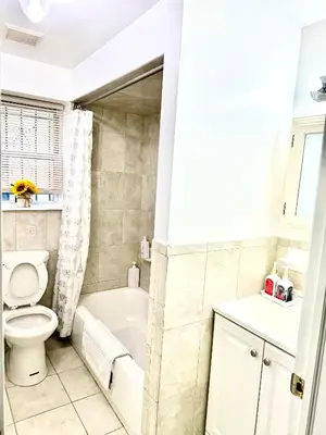 a bathroom with a toilet and a tub and a sink at Cozy Evergreen Apartment by Newark Airport in Newark