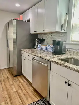 a kitchen with white cabinets and a stainless steel refrigerator at Spacious 4BR home w 2BA, a workspace & king bed! in Fort Plain
