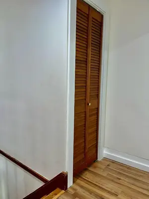 an empty room with a wooden door and stairs at Spacious 4BR home w 2BA, a workspace & king bed! in Fort Plain