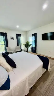 a large white bed in a room with windows at Spacious 4BR home w 2BA, a workspace & king bed! in Fort Plain
