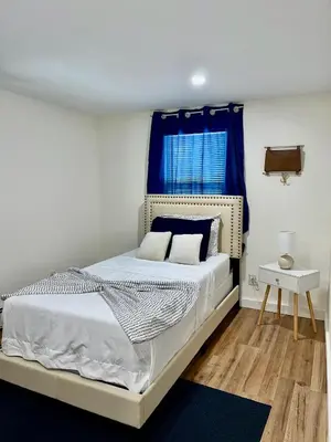 a bedroom with a bed with a blue window at Spacious 4BR home w 2BA, a workspace & king bed! in Fort Plain
