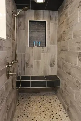 a bathroom with a shower with a tiled wall at Pet Friendly Milford Beachfront Home in Stratford