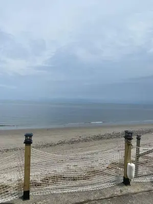 a beach with two posts and a fence at Pet Friendly Milford Beachfront Home in Stratford