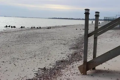 a wooden fence on the beach with the water at Pet Friendly Milford Beachfront Home in Stratford