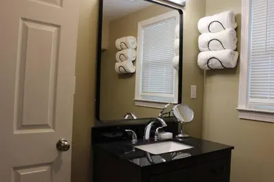 a bathroom with a sink and a mirror and towels at Pet Friendly Milford Beachfront Home in Stratford