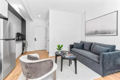 a living room with a couch and a table at Luxe Studio w Juliet Balcony in Upper East in New York