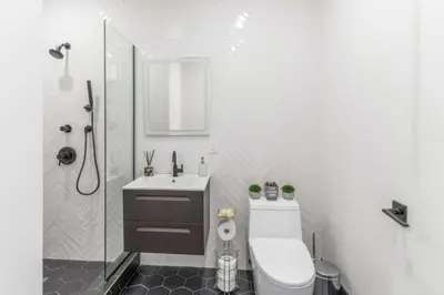 a bathroom with a toilet and a sink and a shower at Luxe Studio w Juliet Balcony in Upper East in New York