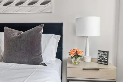 a bedroom with a bed and a table with a lamp at Luxe Studio with Charming Juliet Balcony in New York