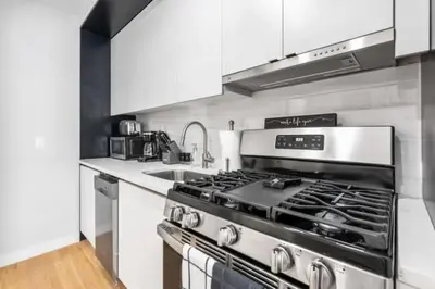 a kitchen with a stove and a sink at Luxe Studio with Charming Juliet Balcony in New York