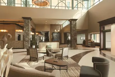 a lobby with couches and chairs in a building at Embassy Suites Saratoga Springs in Saratoga Springs