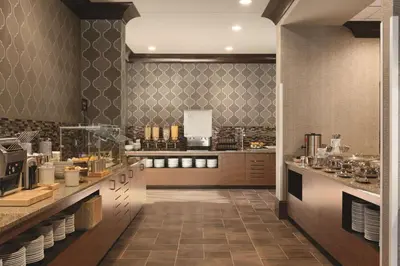 a large kitchen with a counter with many dishes at Embassy Suites Saratoga Springs in Saratoga Springs