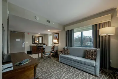 a living room with a couch and a table at Embassy Suites Saratoga Springs in Saratoga Springs