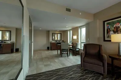 a living room with a chair and a dining room at Embassy Suites Saratoga Springs in Saratoga Springs