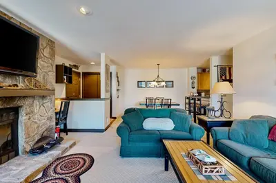 a living room with two blue couches and a fireplace at The Seasons G27 in Dover