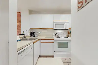 a white kitchen with a sink and a microwave at The Seasons G17 in West Dover