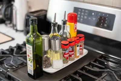 a tray with spices and bottles of wine on a stove at 