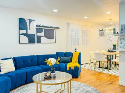 a living room with a blue couch and a table at Lux Designer Home with Gaming Rm in Jersey City